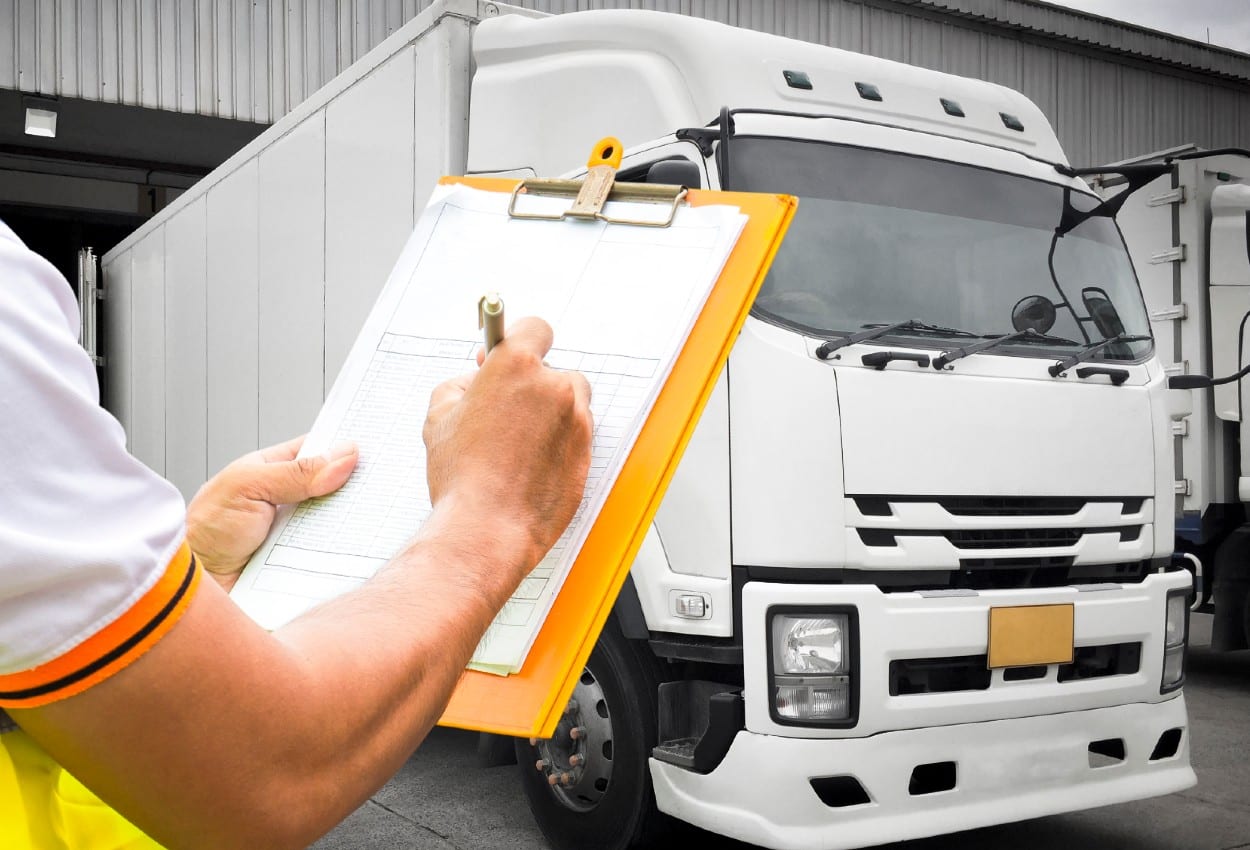 empleado anotada datos en un almacen frente a un camion de autotransporte